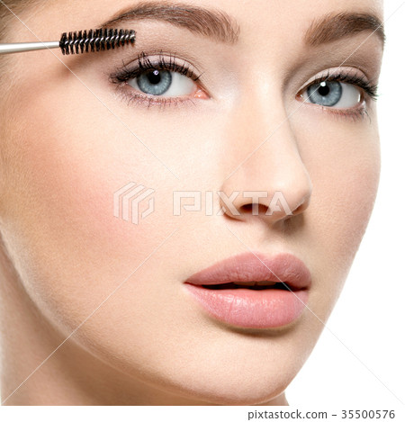 Girl makes makeup. Woman apply mascara on eyelashes Girl makes makeup. Woman apply mascara on eyelashes 35500576