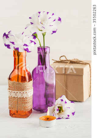 Purple eustoma flowers and lit candle Purple eustoma flowers and lit candle 35502263