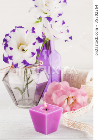 Purple eustoma flowers and lit candle  35502264