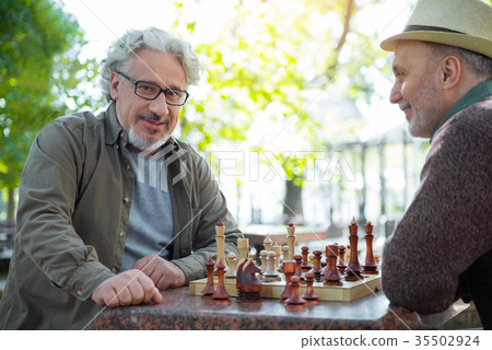 Joyful senior male chess players resting in park Joyful senior male chess players resting in park 35502924