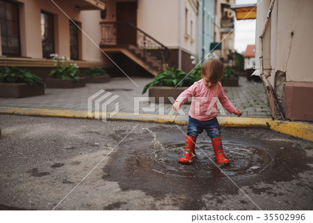 girl plays in the puddle outdoors girl plays in the puddle outdoors 35502996