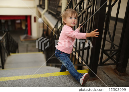 little girl climbs up on stairway little girl climbs up on stairway 35502999