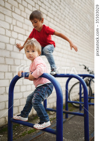 boy and girl climb on bike parking boy and girl climb on bike parking 35503029