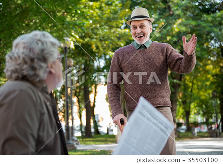 Cheerful mature pensioner greeting his mate Cheerful mature pensioner greeting his mate 35503100