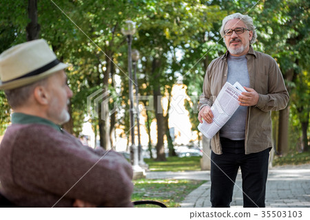 Relaxed male pensioners entertaining in park Relaxed male pensioners entertaining in park 35503103