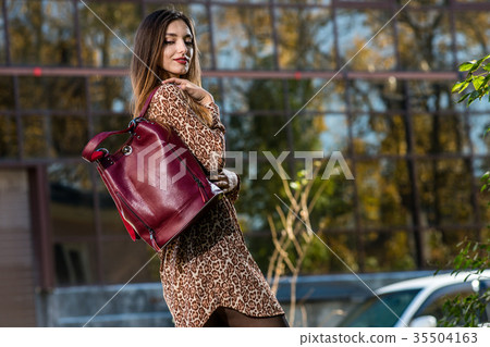 beautiful young woman posing with a leather bag in beautiful young woman posing with a leather bag in 35504163