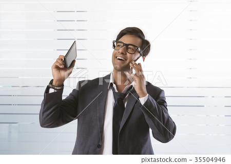 Smiling business executive talking on phone Smiling business executive talking on phone 35504946