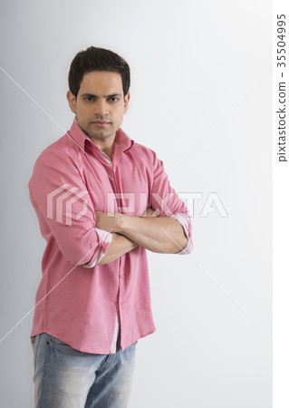 Portrait of young man standing with arms crossed 35504995