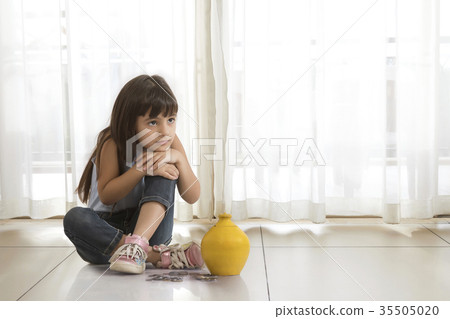 Little girl sitting on floor with clay piggy bank and coins Little girl sitting on floor with clay piggy bank and coins 35505020
