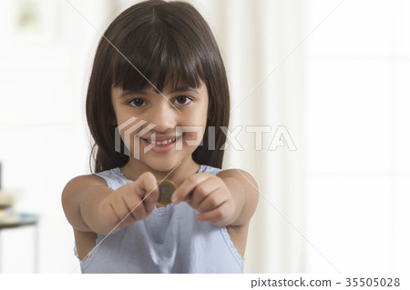 Smiling girl holding coin Smiling girl holding coin 35505028