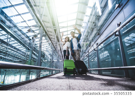 Asian couple traveler with suitcases at the airport. Lover travel and transportation with technology concept. Asian couple traveler with suitcases at the airport. Lover travel and transportation with technology concept. 35505335