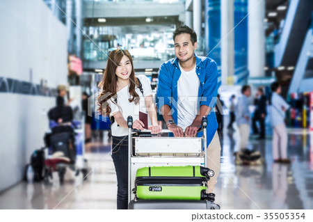 Asian couple traveler with suitcases at the airport. Lover travel and transportation with technology concept. Asian couple traveler with suitcases at the airport. Lover travel and transportation with technology concept. 35505354