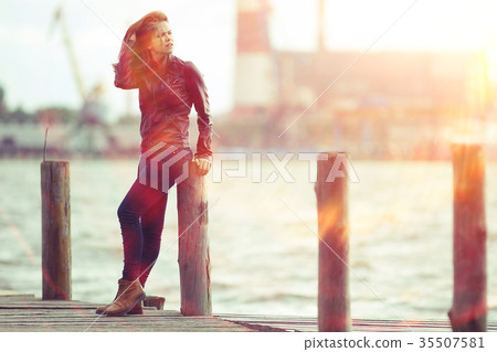 Cheerful happy young adult girl in sunlight rays and wind hair 35507581