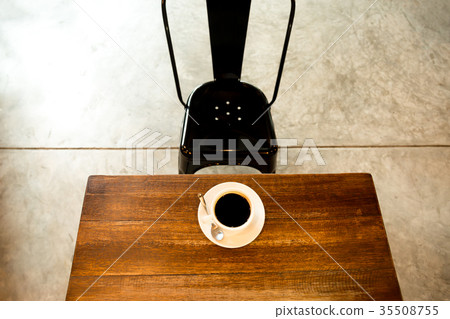 cup of coffee on wooden table with black chair cup of coffee on wooden table with black chair 35508755