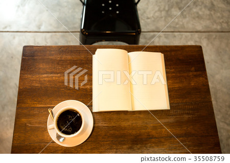 Cup of coffee on wooden table with open book Cup of coffee on wooden table with open book 35508759