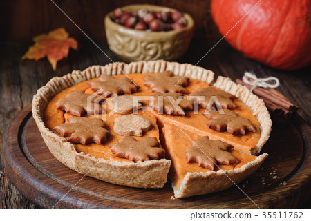 Whole pumpkin pie with pecan nuts and gingerbread 35511762