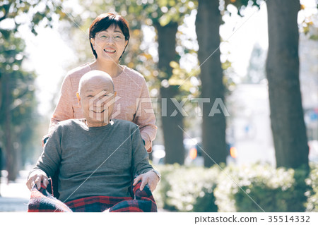 Senior couple going out with a wheelchair Elderly care image 35514332