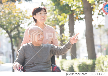 Elderly care senior couple wheelchair walk smile 35514333