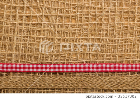 Red ribbon on burlap cloth background Red ribbon on burlap cloth background 35517302