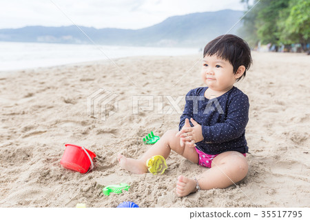 Asian cute girl happy and playing with sand toy. 35517795