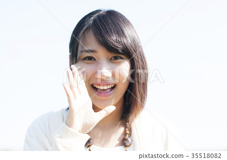 A woman smiling with her hand on her mouth A woman smiling with her hand on her mouth 35518082