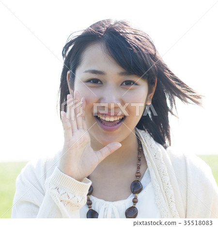 A woman smiling with her hand on her mouth A woman smiling with her hand on her mouth 35518083