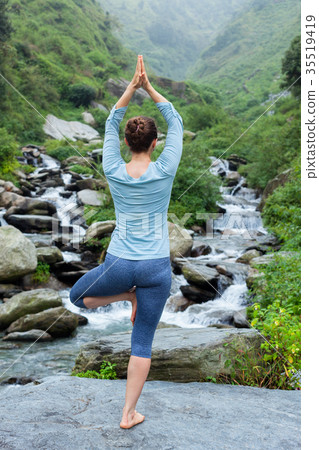 Woman in yoga asana Vrikshasana tree pose at 35519419