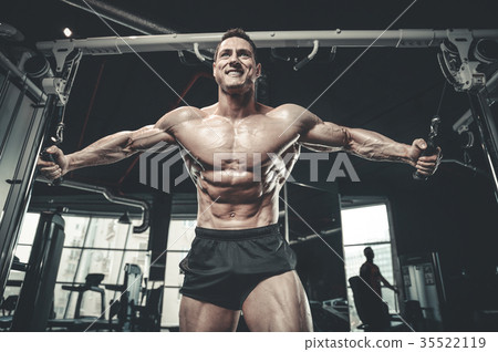 Brutal Caucasian bodybuilder training chest in gym 35522119