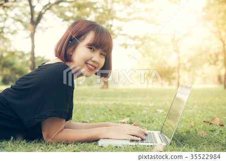 Young asian woman's legs on grass open laptop. Young asian woman's legs on grass open laptop. 35522984