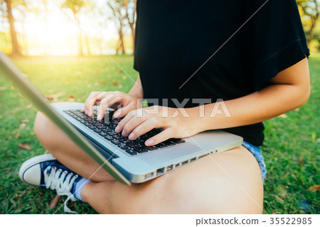 Young asian woman's legs on grass open laptop. Young asian woman's legs on grass open laptop. 35522985