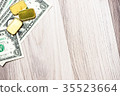 Banknote with gold bar on wooden background 35523664
