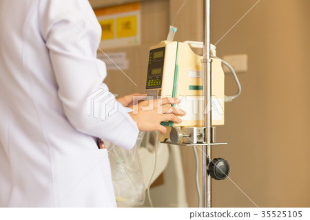 Nurse's hand operating IV machine in patient room Nurse's hand operating IV machine in patient room 35525105