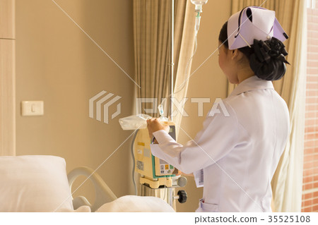 Nurse's hand operating IV machine in patient room 35525108