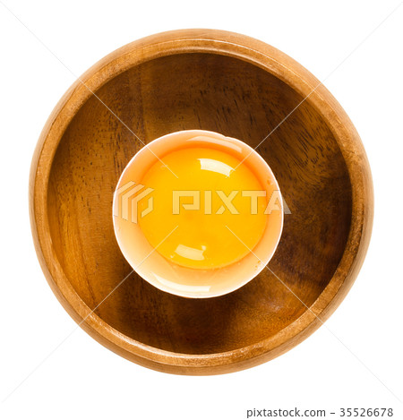 Open raw chicken egg in wooden bowl over white 35526678
