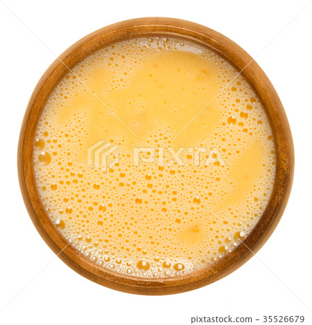 Raw scrambled eggs in wooden bowl over white Raw scrambled eggs in wooden bowl over white 35526679
