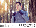Sports man doing boxing exercise in forest. Winter 35528715