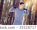 Sports man doing boxing exercise in forest. Winter 35528717