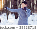 Sports man doing boxing exercise in forest. Winter 35528718