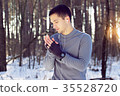 Sports man doing boxing exercise in forest. Winter 35528720
