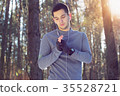 Sports man doing boxing exercise in forest. Winter 35528721