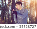 Sports man doing boxing exercise in forest. Winter 35528727
