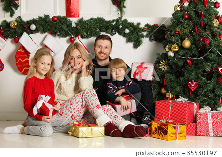 Cheerful family with Christmas gifts Cheerful family with Christmas gifts 35530197