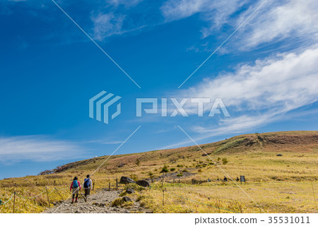 A young couple hiking in the autumn Nagano overlooking the weather radar station from the Kurumayama plateau A young couple hiking in the autumn Nagano overlooking the weather radar station from the Kurumayama plateau 35531011