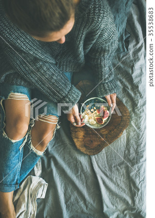 Woman in sweater and jeans eating rice coconut Woman in sweater and jeans eating rice coconut 35538683