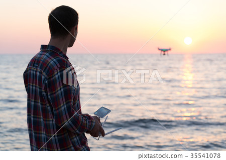 man launches a drone on the beach man launches a drone on the beach 35541078