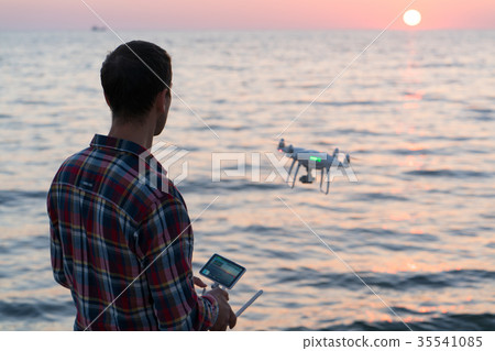 man launches a drone on the beach man launches a drone on the beach 35541085