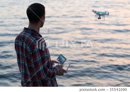 man launches a drone on the beach man launches a drone on the beach 35541090