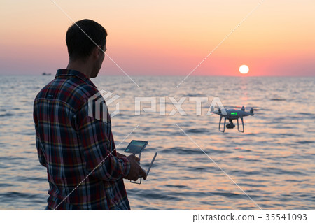 man launches a drone on the beach man launches a drone on the beach 35541093