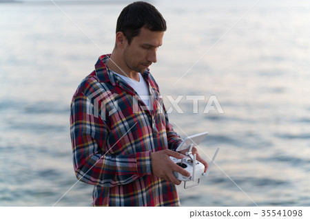 man launches a drone on the beach man launches a drone on the beach 35541098