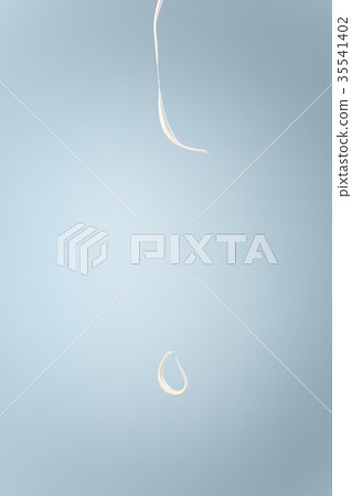 Splash of milk or cream isolated on blue Splash of milk or cream isolated on blue 35541402